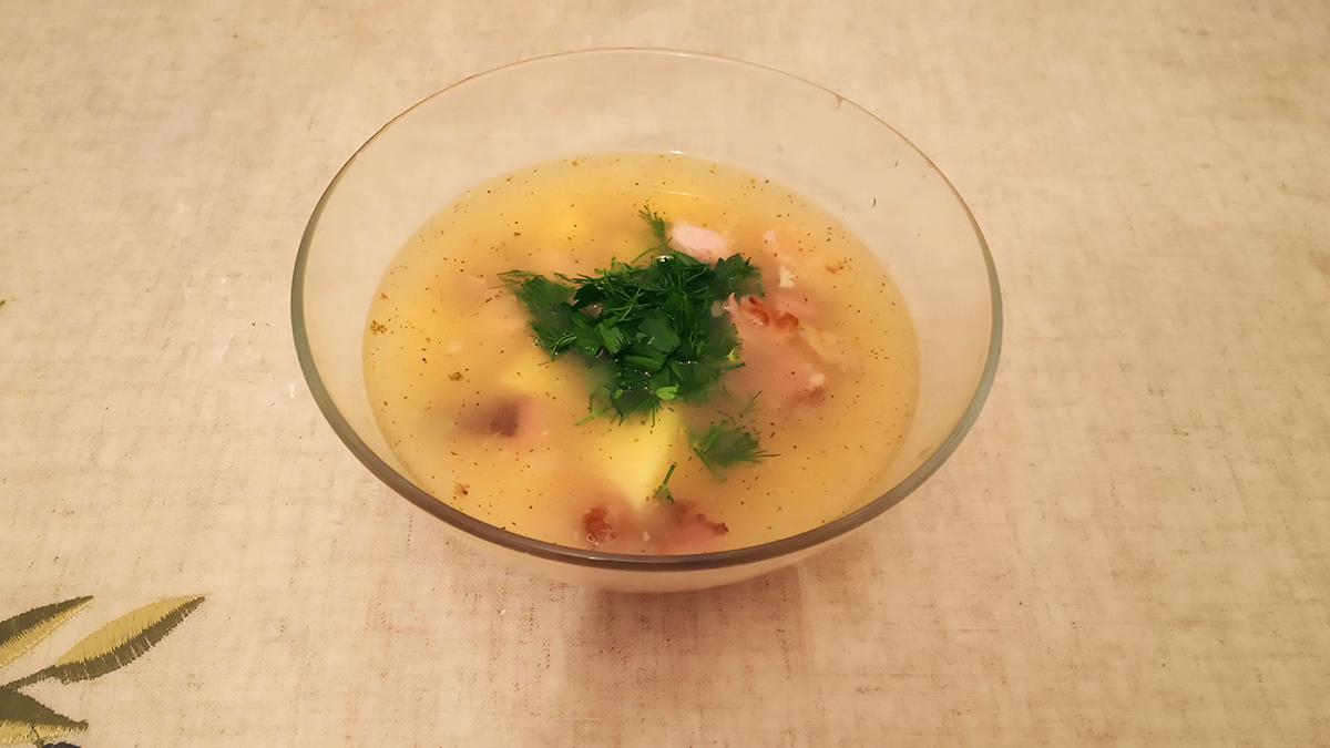 Гороховый суп с копченостями в тарелке.